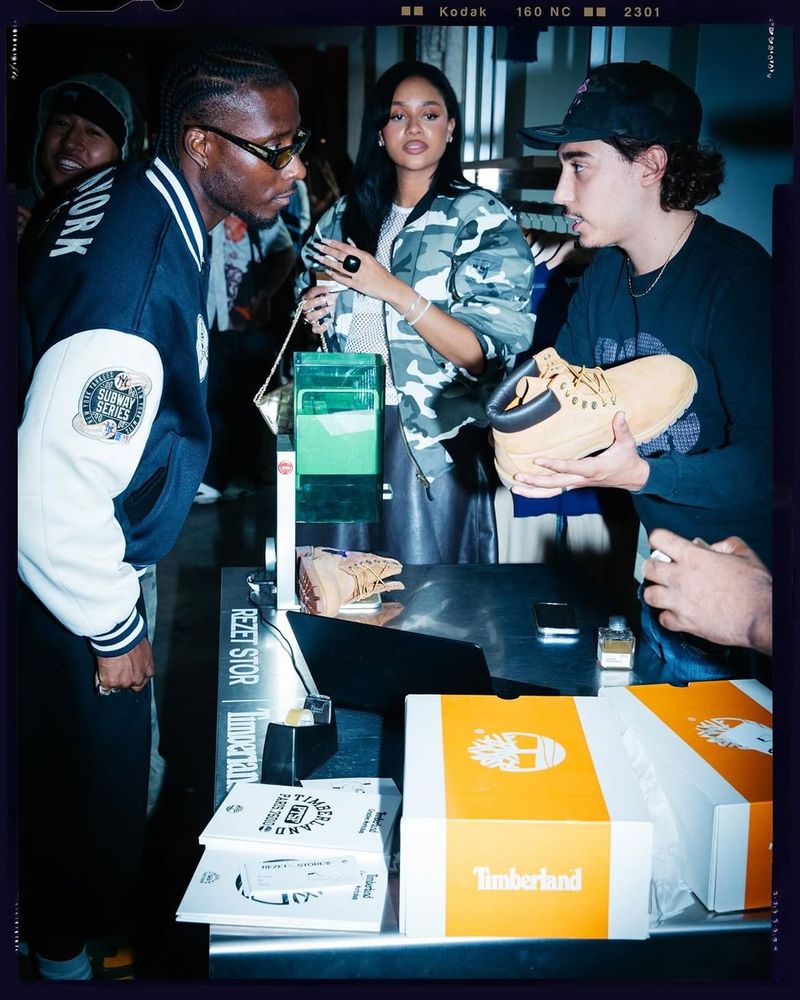 A guest holds up a Timberland boot at the counter during the Timberland × Rezet event.